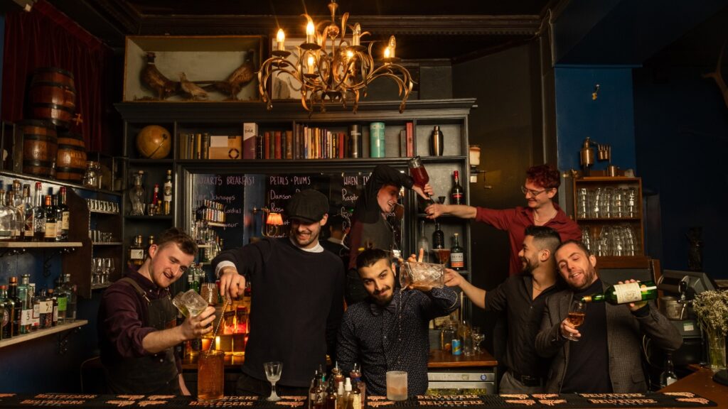 Mixologists at The Milk Thistle secret bar in Bristol pour cocktails in their unique interior